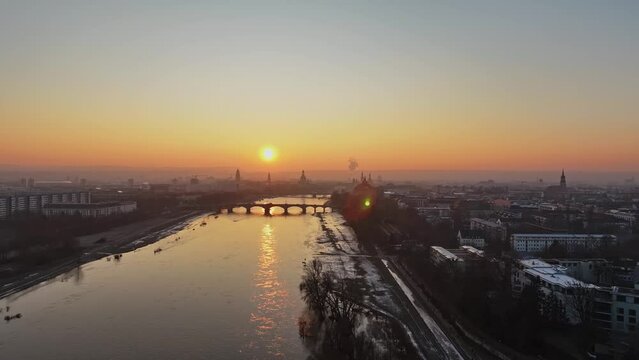 Total Aerial view over the Dresden Elbe at sunset in the winter with sun backlit. Drone move left.
