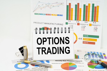 On the table are reports with graphs and a notepad with the inscription - Options trading