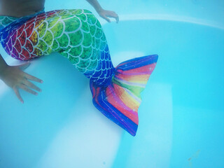 menina criança vestida de sereia em água de piscina no verão  - obrazy, fototapety, plakaty