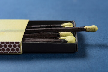 angle view grass green matchbox on a blue background at horizontal composition