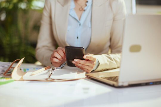 Modern woman employee in green office using phone
