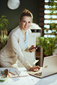 happy woman worker in green office using smartphone