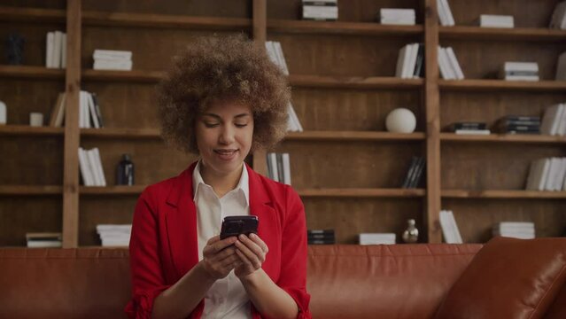 Businesswoman in Red Blazer Texting on Smartphone