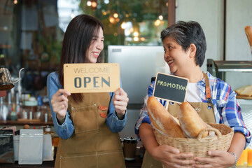 The owner of the cafe beautiful business woman Asian barista employee Taking promotional photo for the store  sign saying welcome and open she turned to smile the single mothersmall family business