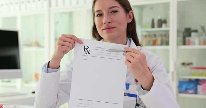 Beautiful female pharmacist holding blank prescription in clinic