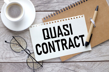 Quasi Contract notepad with pen and sheet of paper with text