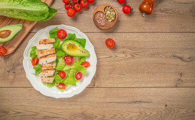 Grilled chicken fillet and fresh vegetable salad on a wooden board. Keto diet food concept. copy space, top view