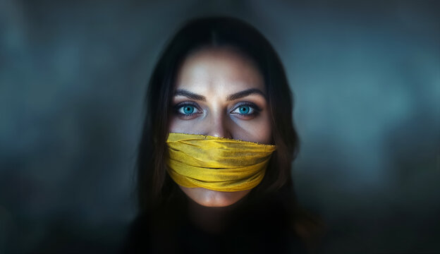 portrait d'une femme, vu de face, avec un b&acirc;illon jaune devant la bouche 