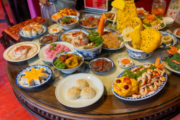 Tet tray. Full of traditional dishes. Chinese new year festival table with asian food. Vietnamese food for Tet holiday in lunar new year. Text on food meaning happy and peaceful.