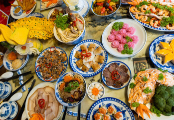 Tet tray. Full of traditional dishes. Chinese new year festival table with asian food. Vietnamese food for Tet holiday in lunar new year. Text on food meaning happy and peaceful. - obrazy, fototapety, plakaty