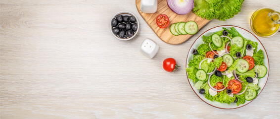 Fototapeta na wymiar Healthy salad with cheese and fresh vegetables on a light background. Long banner format. top view