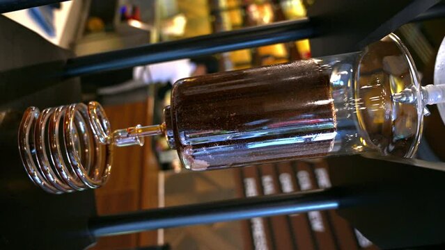 Making Dutch Cold Brew Coffee by Dripper: water, ground coffee, coiled glass tube, cold brewed