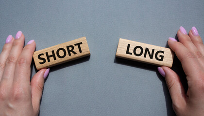 Short vs Long symbol. Concept word Short vs Long on wooden blocks. Businessman hand. Beautiful grey background. Business and Short vs Long concept. Copy space