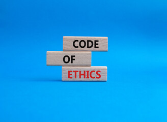 Code of ethics symbol. Concept words Code of ethics on wooden blocks. Beautiful blue background....