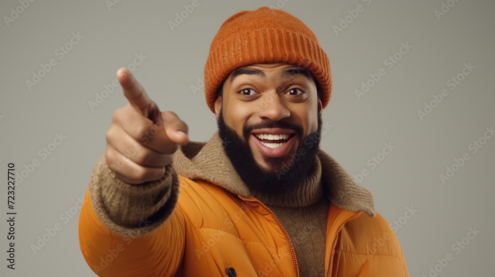 Poster A man wearing an orange jacket is pointing directly at the camera. This image can be used to convey a sense of confidence, engagement, or to emphasize a specific message