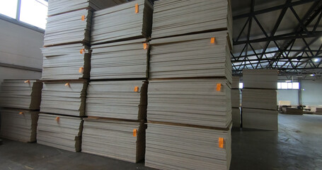 Sheets of plywood slabs are stacked in the warehouse of the woodworking plant