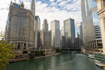 Fototapeta premium Riverwalk passes between the tall buildings in the city. Towers and water.