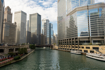 Riverwalk passes between the tall buildings in the city. Towers and water.