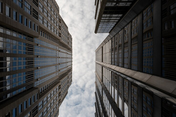 Two skyscrapers almost touching each other above the sky