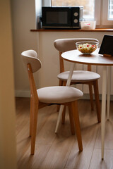 Chairs and table with salad, diet vegetable salad on the table , kitchen modern wooden interior