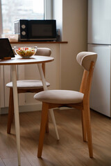 Chairs and table with salad, diet vegetable salad on the table , kitchen modern wooden interior