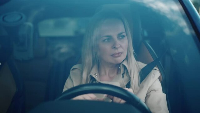 Stressed annoyed woman driver sitting inside broken car. Angry female driver driving a car. Angry young woman late for work and stuck in a traffic jam. Exhausted girl stuck in traffic. Car breakdown
