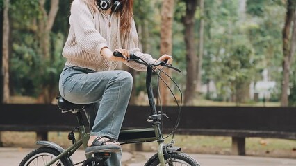 Bicycle, woman and phone in city feeling excited and happy about message while outdoor in summer with trendy look. Eco friendly transportation for carbon footprint female on a bike using 5g network