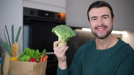 Man eating a raw broccoli 