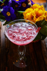 cosmopolitan cocktail garnished with ice on wooden table