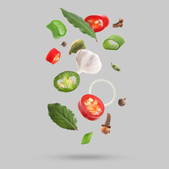 Different spices falling on light grey background