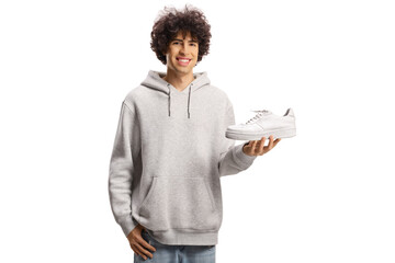 Guy holding a white sneaker and smiling