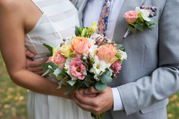 Tender hands cradle a bridal bouquet