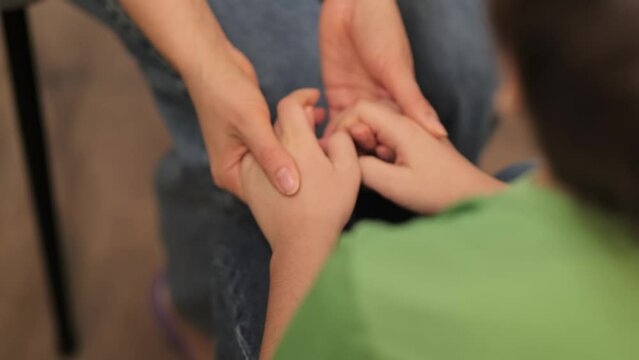 The nurturing touch from a caregiver to a child in need, symbolizing the protective bond and emotional sanctuary provided.