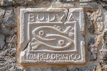Historic symbol of Budva on wall of the ancient citadel in the Old City of Budva in Montenegro