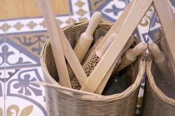 Wooden rolling pins, slats, pottery workshop accessories in a wicker basket. Selective Focus