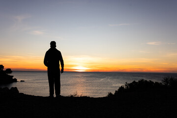 Fototapeta premium Person at sunrise at sea taking pictures