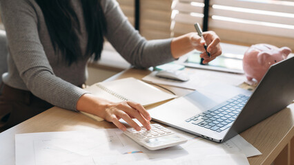 Close up hand of Business woman using laptop while plan and discussion information for financial in home office. Beautiful woman happy and working at indoors.