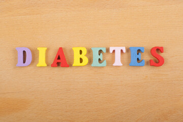 DIABETETES word on wooden background composed from colorful abc alphabet block wooden letters, copy space for ad text. Learning english concept.
