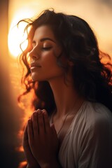 A woman is shown praying in front of the sun. This image can be used to depict spirituality and devotion