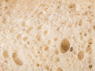 Rustic close-up of sliced bread texture from top view, golden crust wheat loaf