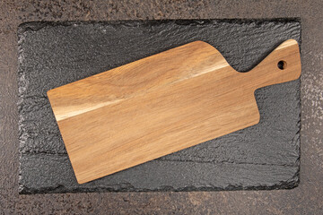 Top view of black stone and wooden cutting boards with space for text