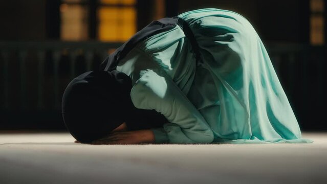 Woman Prostrating in Islamic Prayer in a Mosque at Night. Ramadan Praying