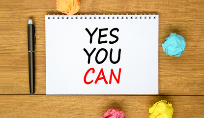 Motivational Yes you can symbol. Concept words Yes you can on beautiful white note. Beautiful wooden background. Black pen. Colored paper. Business motivational and Yes you can concept. Copy space