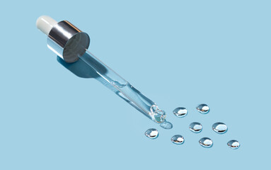 Cosmetic pipette with drops of gel on a blue background.