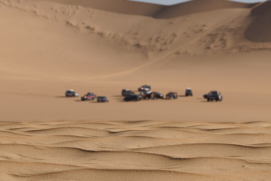 Off-road vehicles caravan traversing desert dunes