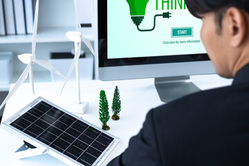 Businessman working in office developing plan or project on eco-friendly alternative energy with...