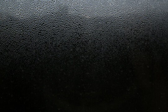 Closeup of heavy water condensation on window glass during a winter morning. 