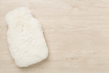 Fluffy water warmer bag on wooden background