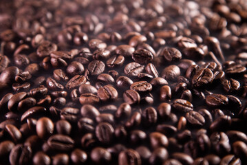 Close-up of fresh roasted coffee beans and smoky. Coffee beans background