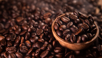 Close-up of roasted coffee beans in a brown wooden bowl. Coffee beans background.